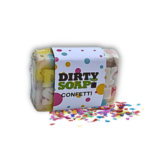 A rectangular Confetti Soap Bar by Dirty Soap, infused with Bergamot Essential Oil, rests on a white background scattered with loose confetti and features a "Dirty Soap Confetti" label.