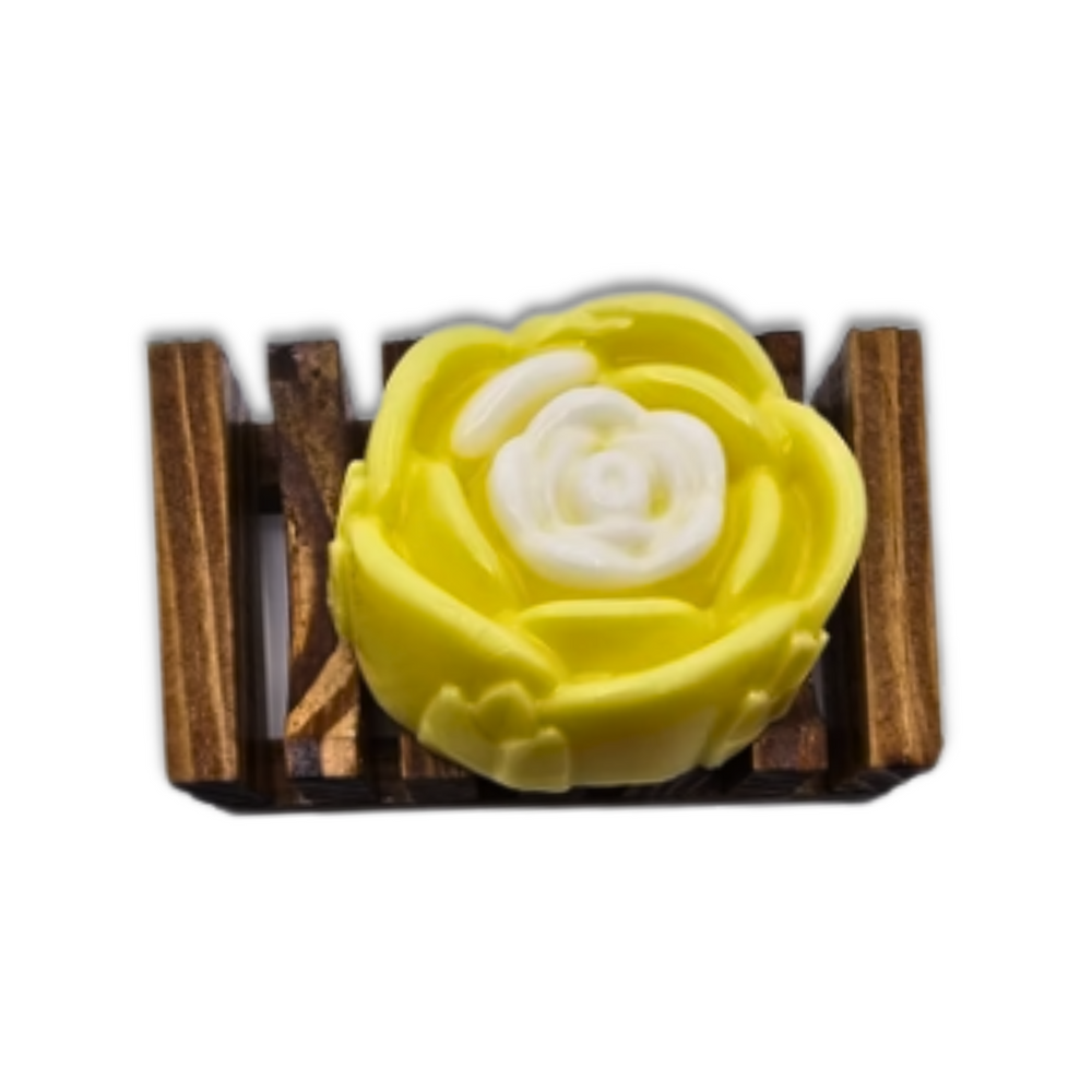 A Yellow Rose Honeysuckle & Jasmine Flower Soap by Dirty Soap Shoppe, designed for stress relief, sits on a small wooden soap dish.
