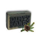 The Open Air Bar Soap by Dirty Soap, infused with Douglas Fir and Cedarwood Essential Oils, features "DIRTY SOAP" embossed on its rectangular surface and is styled beside a pinecone and pine branch.