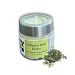 A jar of Dirty Soap Bubbles Lemongrass And Patchouli Whipped Body Butter, 3.0 oz (89 ml), is placed next to a small pile of dried patchouli leaves.