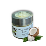 A glass jar of Dirty Soap Bubbles Original Whipped Body Butter with a metal lid is displayed by coconut halves and green leaves, emphasizing this organic moisturizer’s natural hydration for your skin.