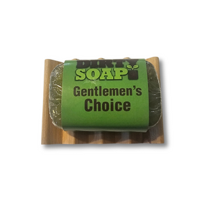 A green Dirty Soap Mini Bar by Dirty Soap rests on a wooden soap dish against a white background—ideal for anyone who enjoys mini soaps or wants to sample new varieties.