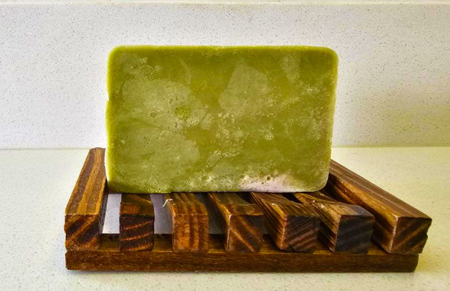 A bar of Girl's Undercover Bar Soap from Dirty Soap resting on a wooden soap dish.