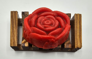 A Red Rose Flower Soap by Dirty Soap Shoppe sits on a small wooden rack, set against a white background, infused with the refreshing aroma of Spearmint Essential Oil.