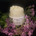 Jar of Dirty Soap Bubbles Lavender Whipped Body Butter surrounded by purple flowers and greenery.