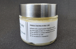 Glass jar containing Dirty Soap Bubbles Lemongrass And Patchouli Whipped Body Butter with natural ingredients and label instructions for use.