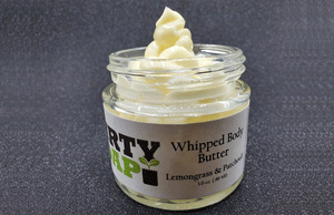 A jar of Lemongrass And Patchouli Whipped Body Butter with a dollop of the Dirty Soap Bubbles product on display, crafted with natural ingredients.