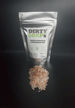 A package of Dirty Soap Sunrise Grapefruit & Himalayan Salt Bath Salts with a pile of Pink Himalayan Salt in front of it.